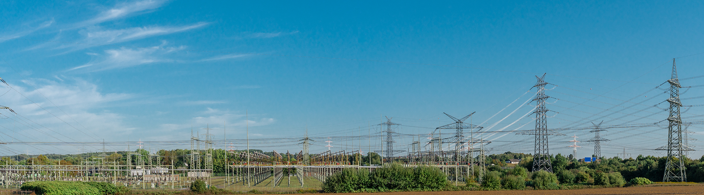 Panoramic view of a high-voltage transmission substation and multiple power lines