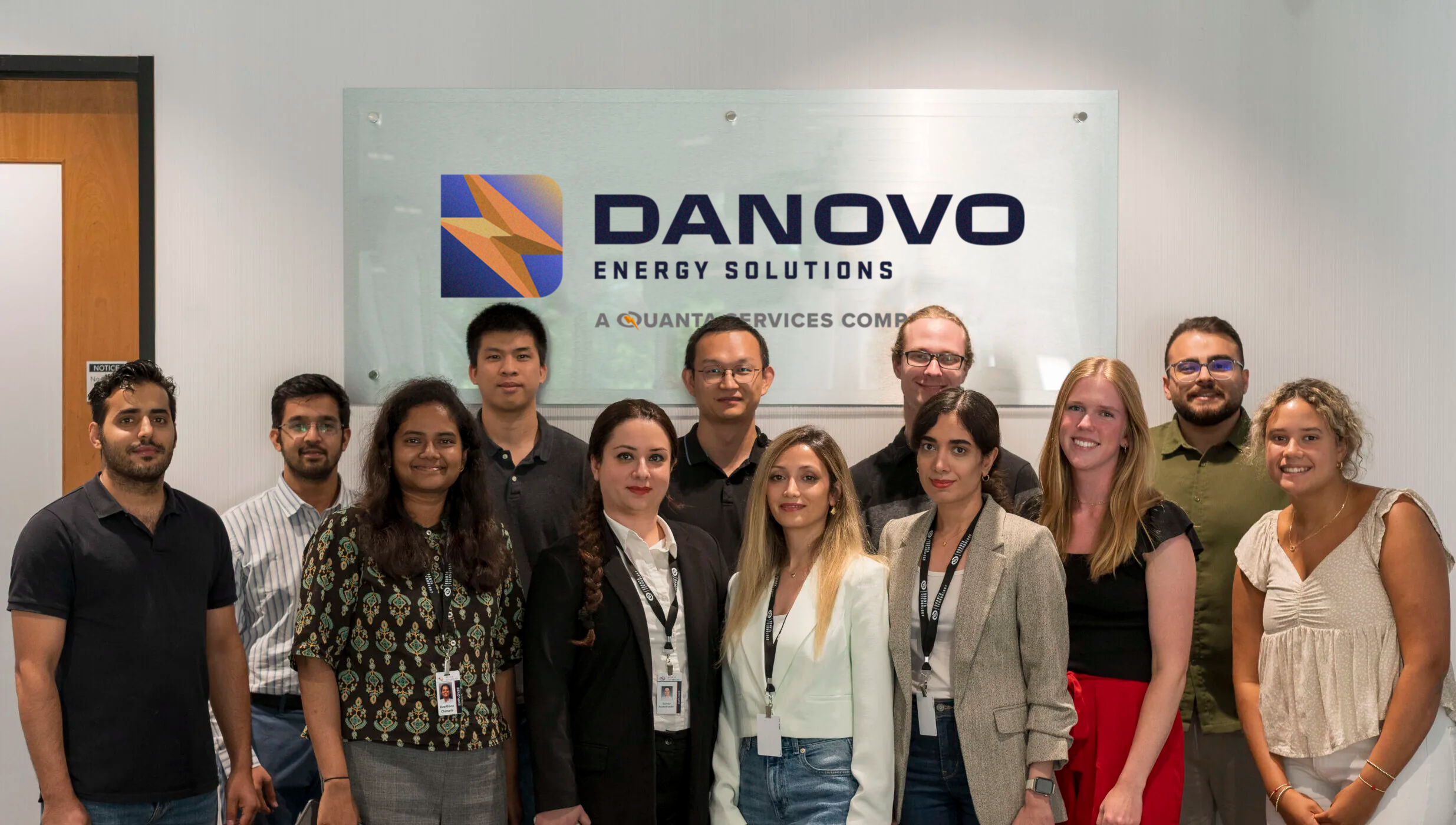 Group of Danovo Energy Solutions interns in front of a lobby sign.