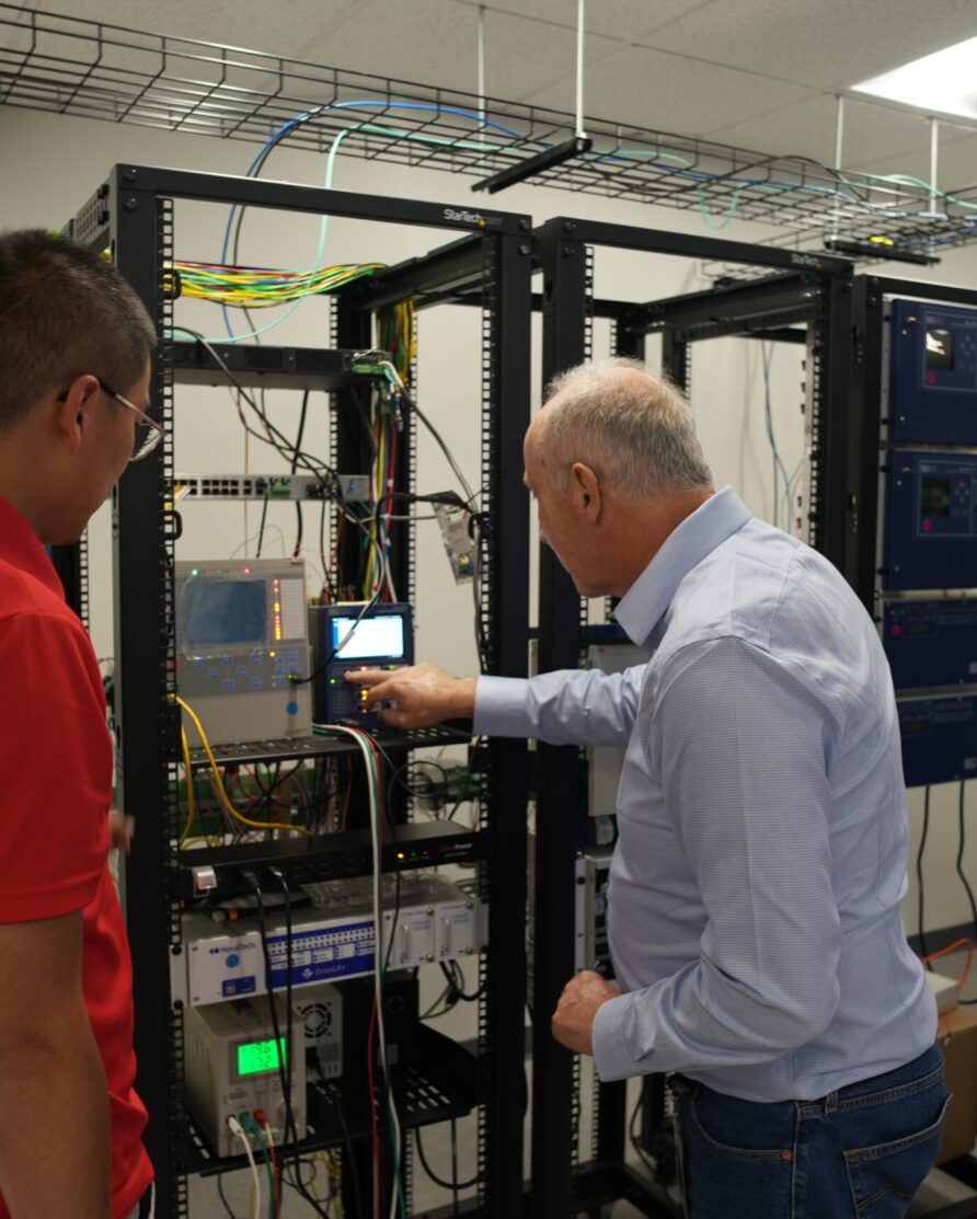 Two Danovo Energy Solutions employees experimenting in the RTDS lab