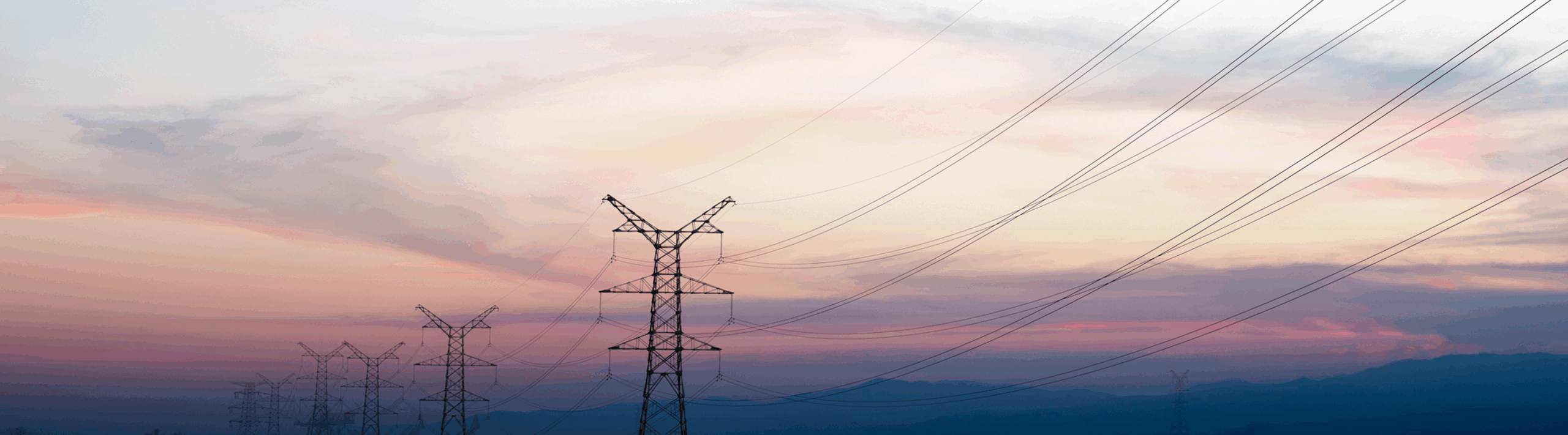 Transmission towers in front of a purple and pink sunset sky.