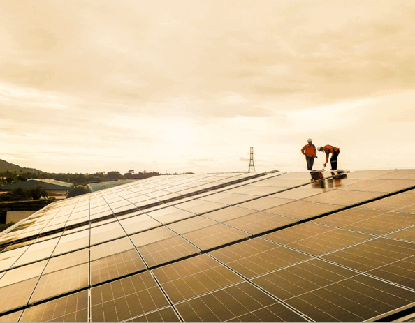 Workers inspecting a large solar photovoltaic panel array at a renewable energy site.