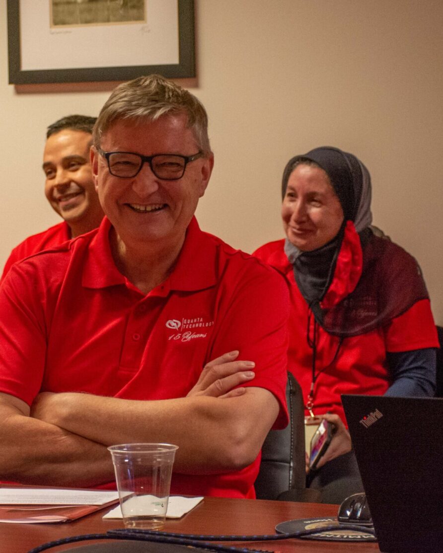Damir Novosel, founder, grinning in a conference room with other employees.