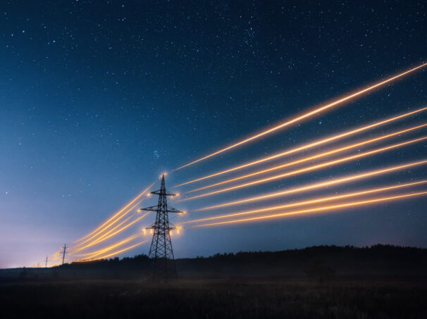Glowing high voltage transmission lines in the night sky.