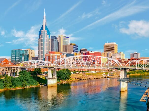 Nashville, Tennessee skyline with bridge, buildings, and water.