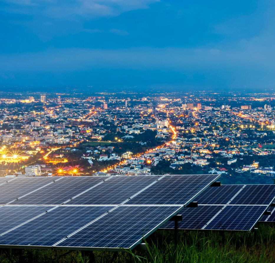 Solar energy in front of a city at night showing distributed energy resources for distribution.