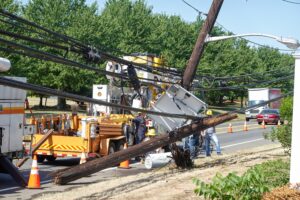 Repairing a broken wooden power line after a storm.